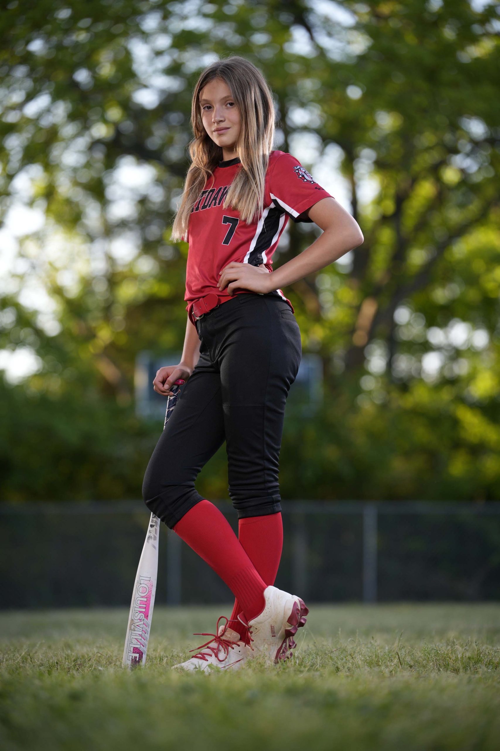 An image of a young girl posing with her baseball bat.